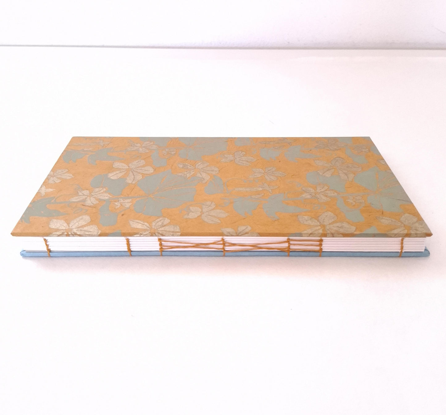 Taccuino con pagine avorio e copertine floreali in ocra, oro e verde acqua