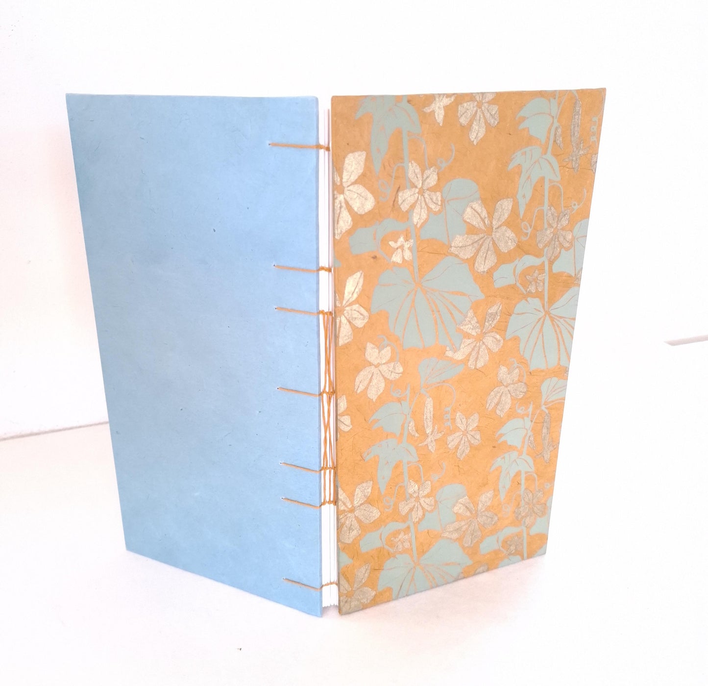 Taccuino con pagine avorio e copertine floreali in ocra, oro e verde acqua