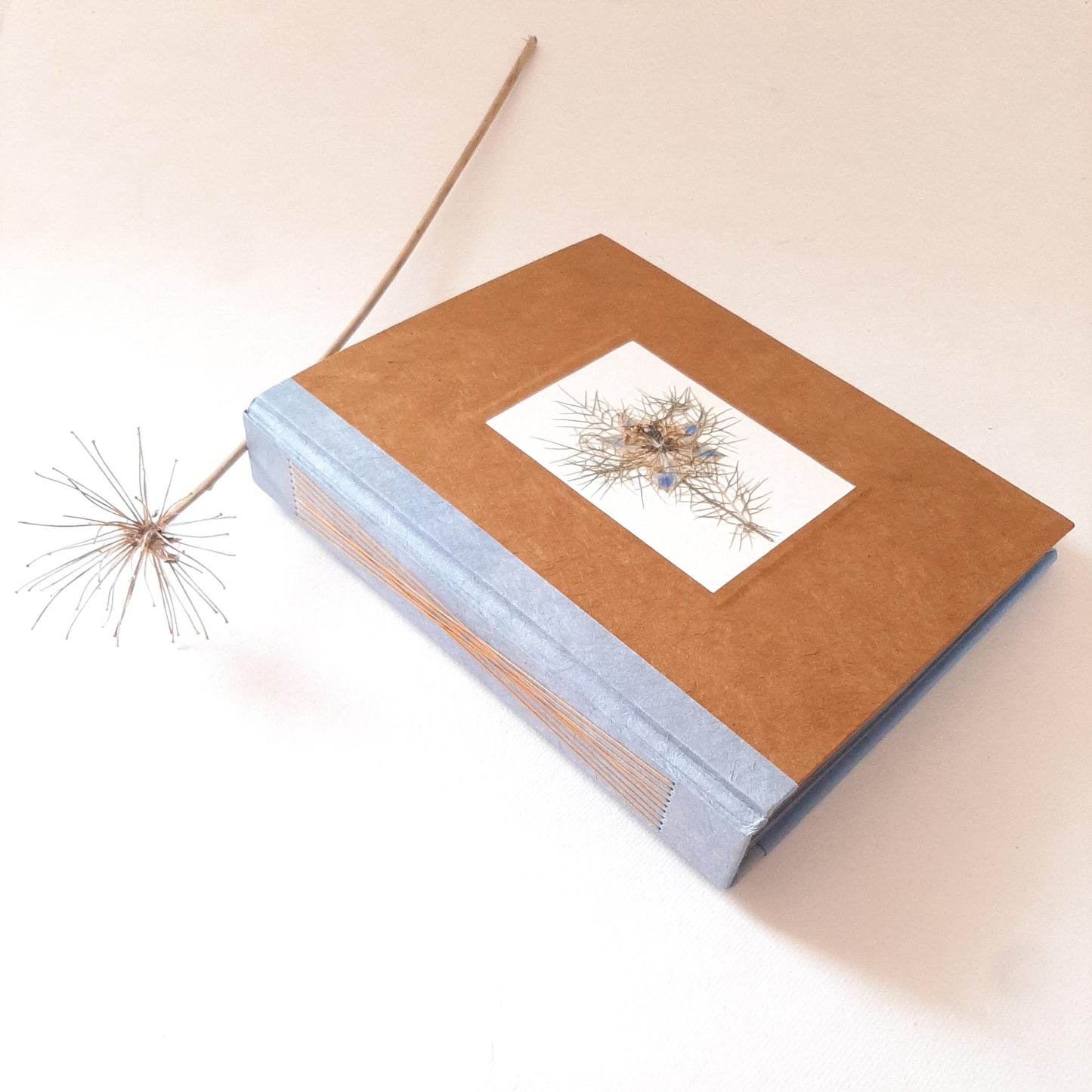 Album fotografico grande con fiore pressato di Nigella in ocra e azzurro pervinca