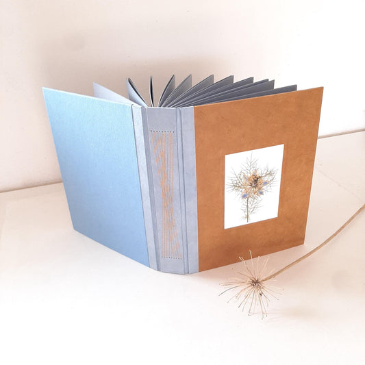 Album fotografico grande con fiore pressato di Nigella in ocra e azzurro pervinca