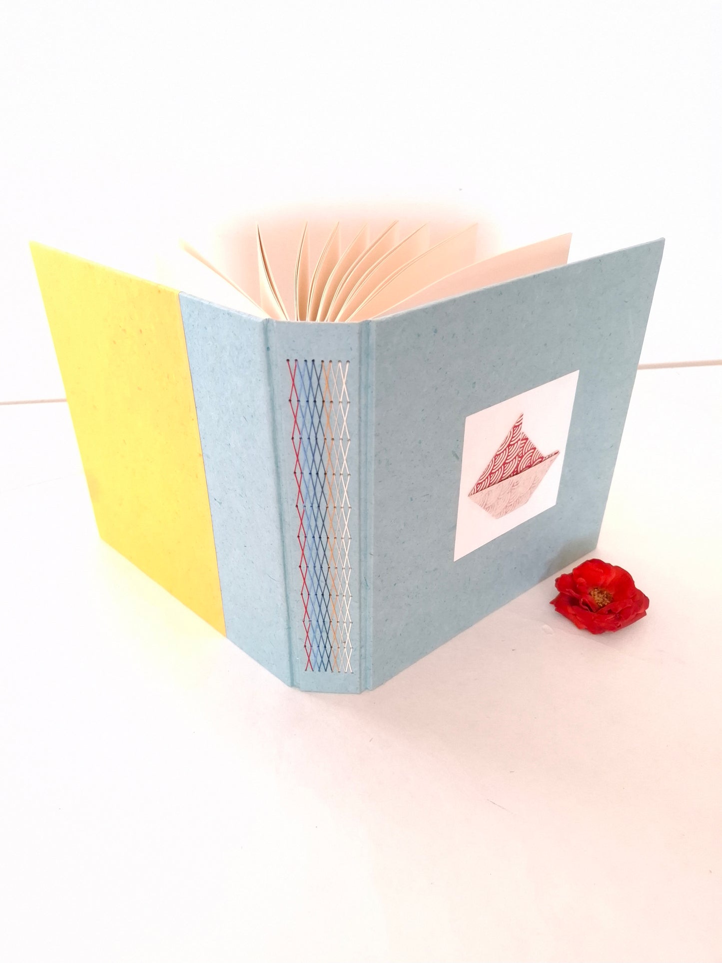 Album nascita con barca origami in rosso, celeste e miele