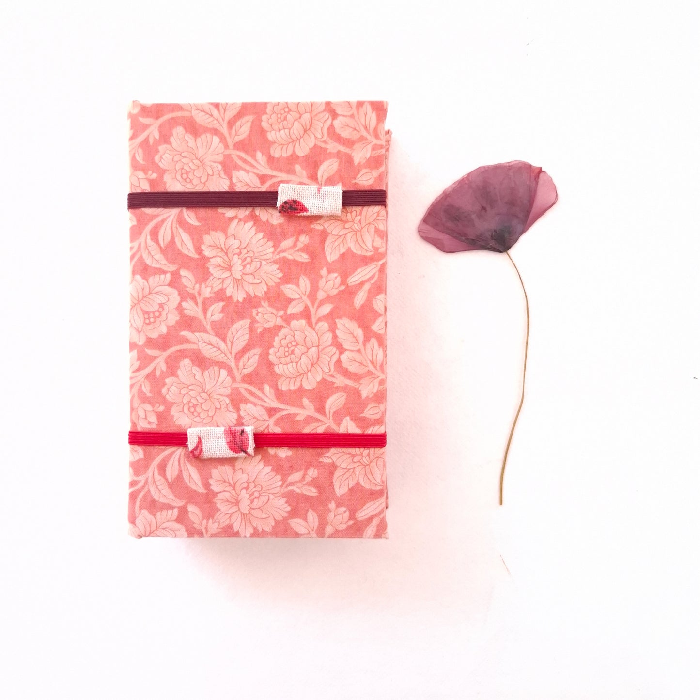 Pressa per fiori da viaggio foderata in tessuto con fiori rosa e corallo