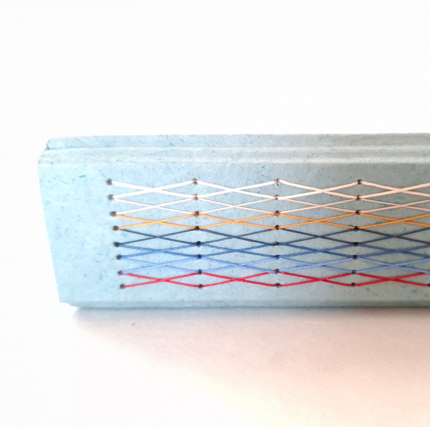 Album nascita con barca origami in rosso, celeste e miele